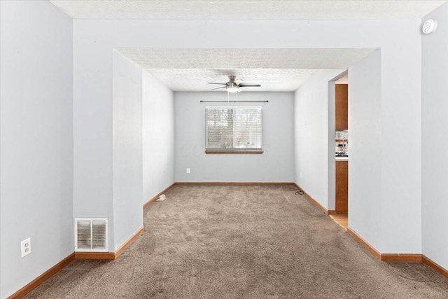 carpeted spare room with ceiling fan and a textured ceiling