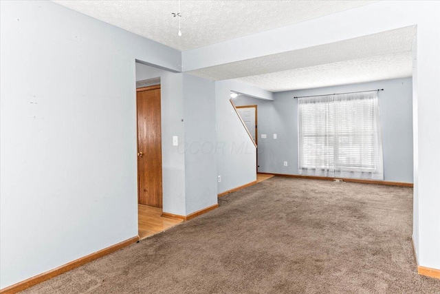 carpeted spare room with a textured ceiling