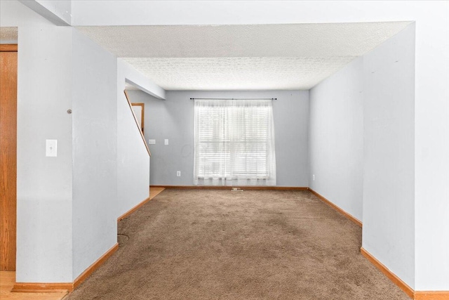 unfurnished room featuring carpet and a textured ceiling