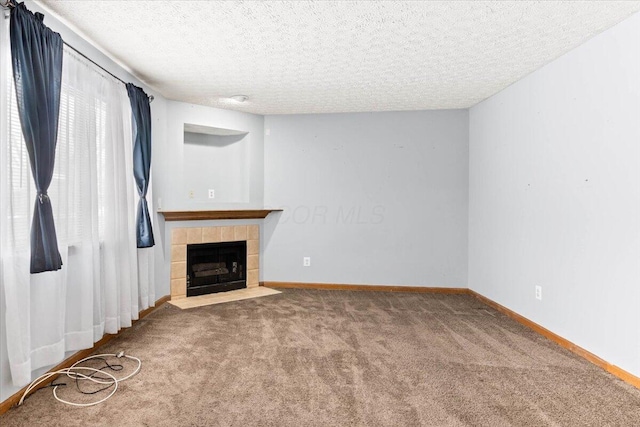 unfurnished living room featuring carpet, a fireplace, and a textured ceiling