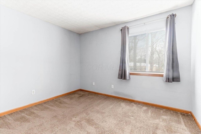 spare room featuring carpet floors and a textured ceiling