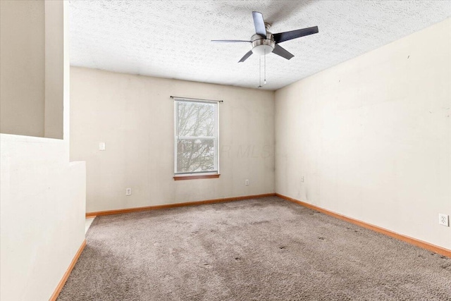 carpeted empty room with ceiling fan and a textured ceiling