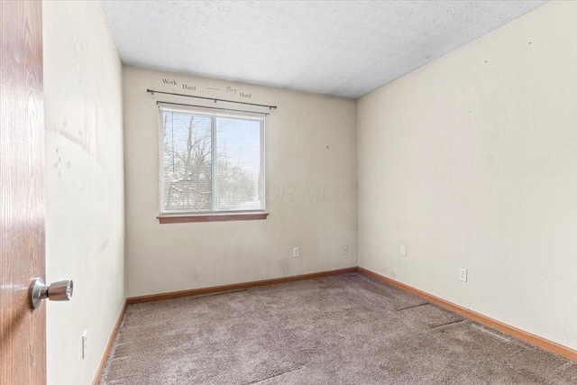 carpeted empty room featuring a textured ceiling