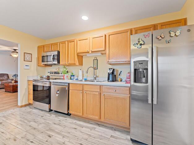 kitchen featuring ceiling fan, sink, light brown cabinets, appliances with stainless steel finishes, and light wood-type flooring