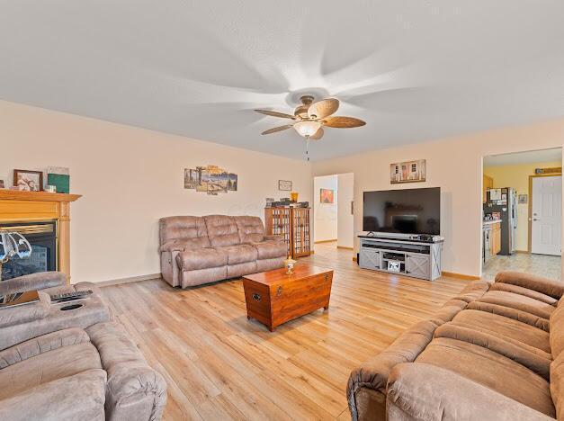 living room with light hardwood / wood-style flooring and ceiling fan