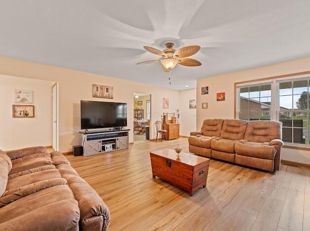 living room featuring ceiling fan and light hardwood / wood-style floors