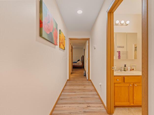 hallway featuring light wood-type flooring and sink