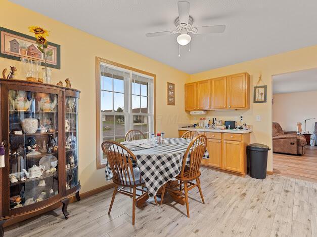 dining area featuring light wood-type flooring and ceiling fan