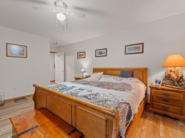 bedroom with ceiling fan and light hardwood / wood-style floors