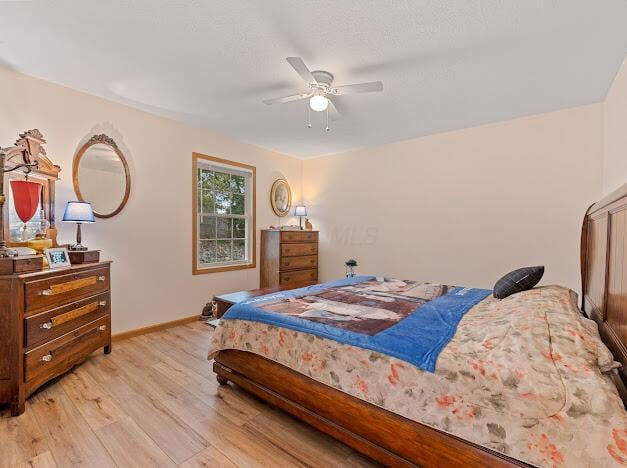 bedroom with light hardwood / wood-style floors and ceiling fan