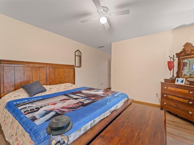 bedroom with light hardwood / wood-style flooring and ceiling fan