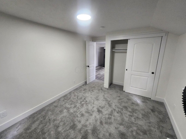 unfurnished bedroom featuring carpet floors, a closet, and lofted ceiling