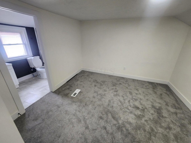 carpeted empty room featuring lofted ceiling