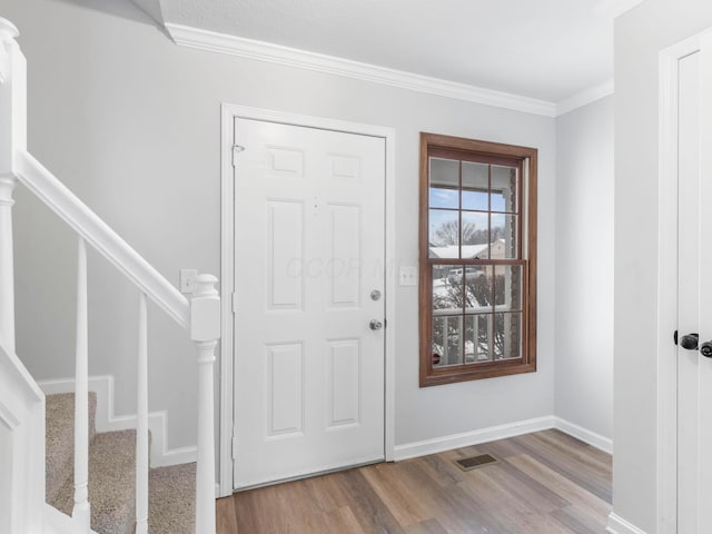 foyer featuring light wood-type flooring and ornamental molding