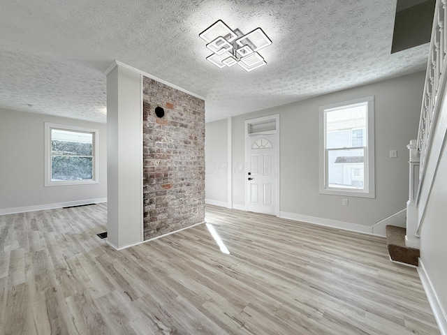 entryway featuring plenty of natural light, a textured ceiling, and light hardwood / wood-style flooring