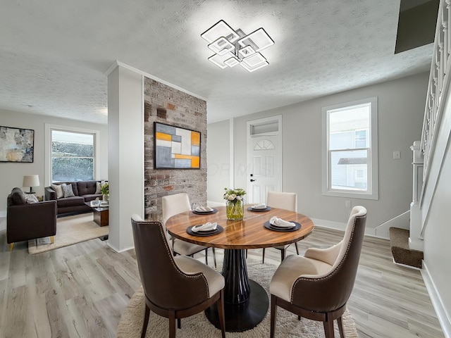 dining area featuring light hardwood / wood-style floors and a textured ceiling