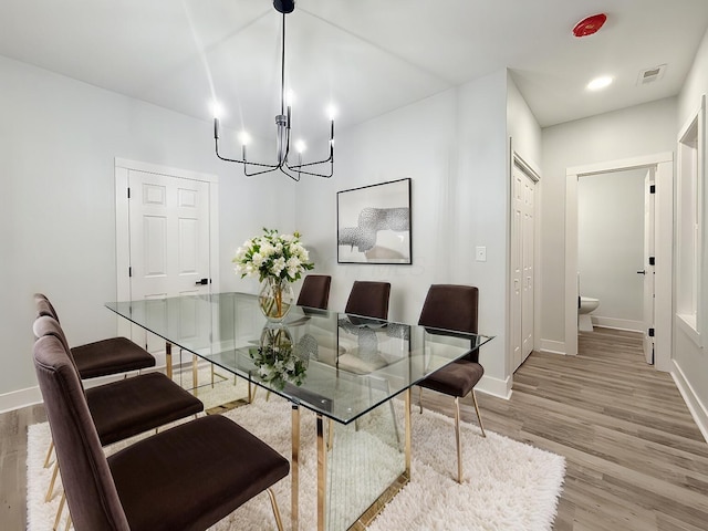 dining room with an inviting chandelier and hardwood / wood-style flooring