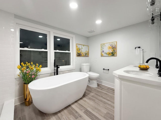 full bathroom featuring hardwood / wood-style flooring, vanity, separate shower and tub, and toilet