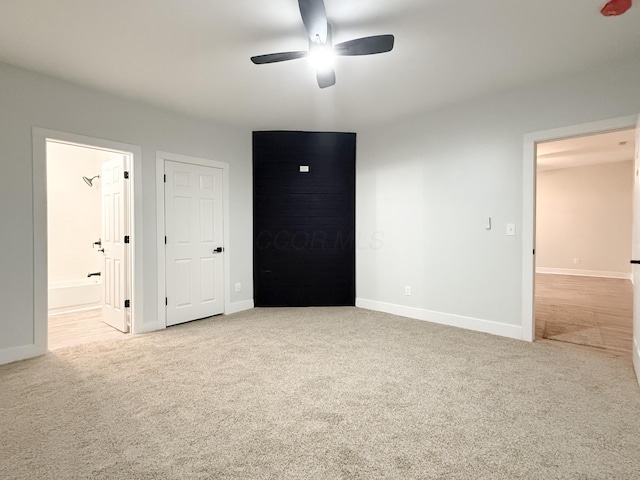 unfurnished bedroom with ensuite bath, light colored carpet, and ceiling fan