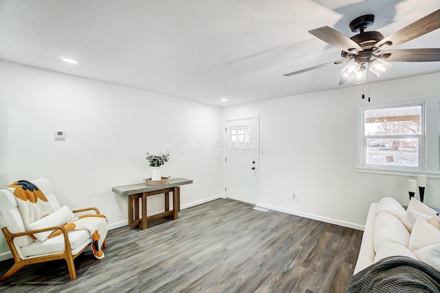 living area featuring ceiling fan, dark hardwood / wood-style flooring, and a healthy amount of sunlight