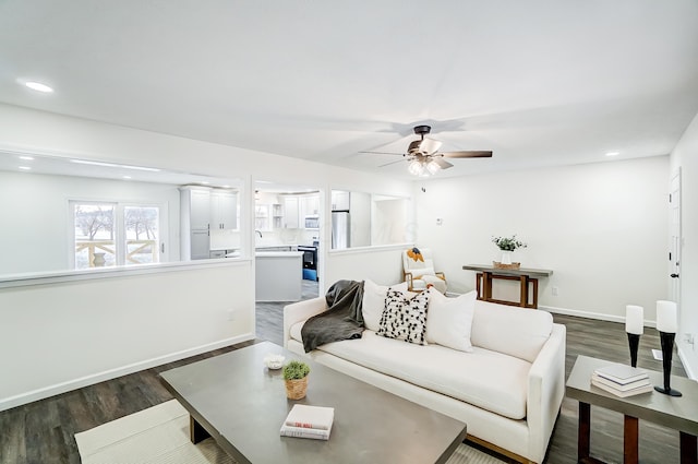 living room featuring ceiling fan, dark wood-type flooring, and sink