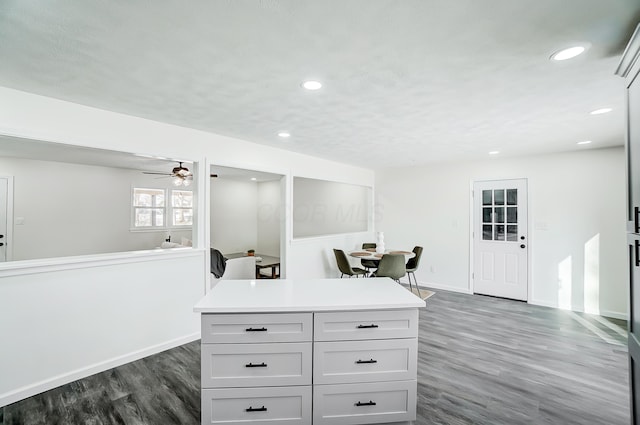 bar with ceiling fan and dark hardwood / wood-style flooring