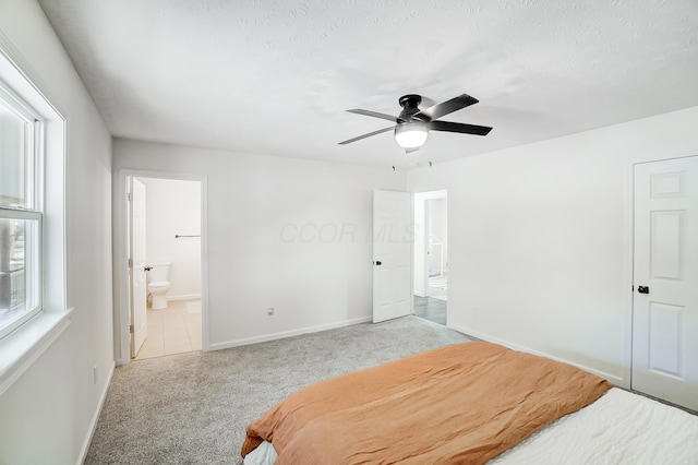 bedroom featuring ceiling fan, light carpet, and connected bathroom