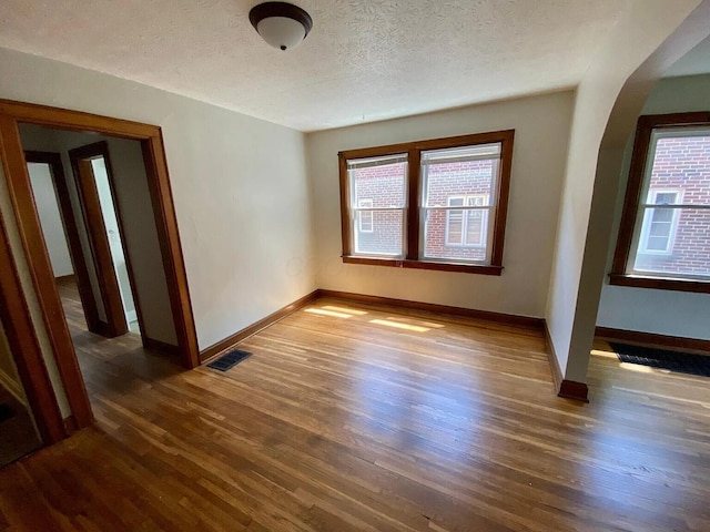 unfurnished room featuring a textured ceiling and dark wood-type flooring