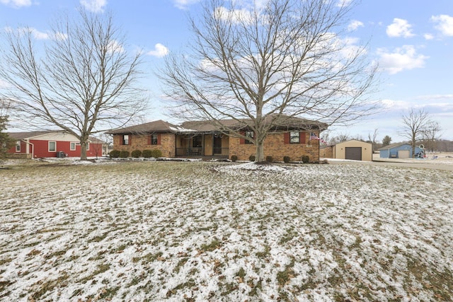 ranch-style home featuring a garage, brick siding, and an outbuilding