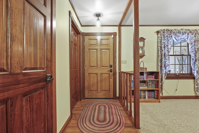 foyer featuring baseboards and crown molding