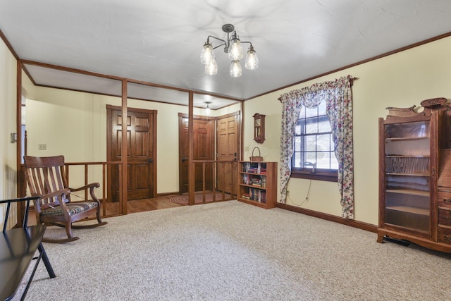 living area with ornamental molding, carpet flooring, a notable chandelier, and baseboards