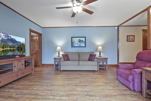 living room featuring light wood-style flooring, ornamental molding, and baseboards