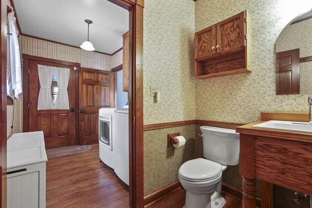 bathroom featuring wallpapered walls, toilet, wood finished floors, vanity, and separate washer and dryer