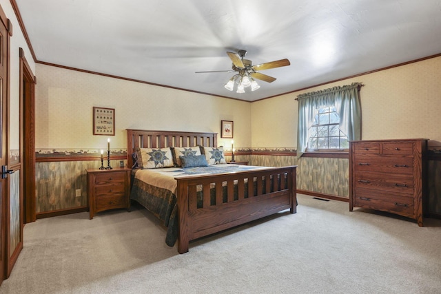 carpeted bedroom with wallpapered walls, visible vents, crown molding, and wainscoting