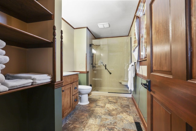 full bath featuring toilet, stone finish floor, ornamental molding, vanity, and a shower stall