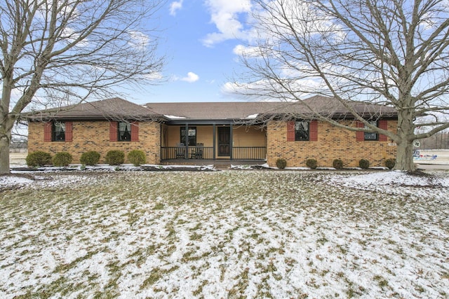 ranch-style house featuring a porch and brick siding