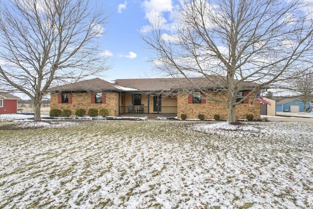 single story home featuring a porch and brick siding