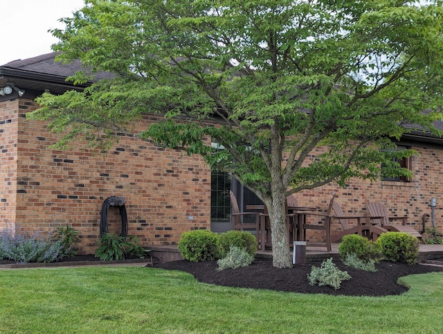 view of side of property with a yard and brick siding