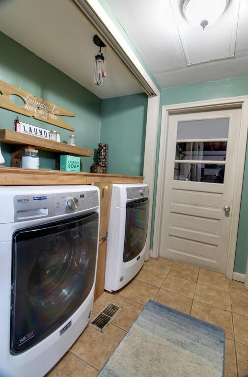 clothes washing area featuring independent washer and dryer and light tile patterned floors