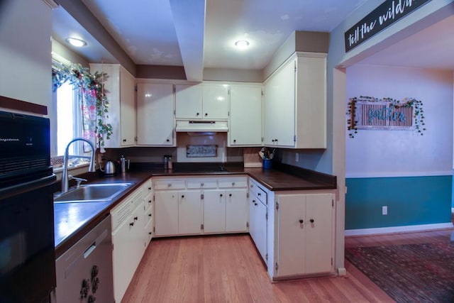 kitchen with white cabinets, sink, stainless steel dishwasher, black oven, and light hardwood / wood-style floors