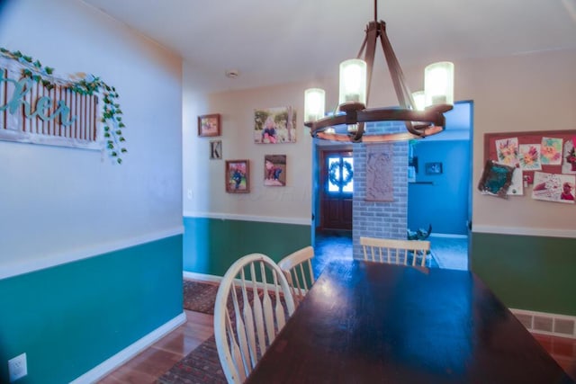 dining room featuring hardwood / wood-style floors and a chandelier