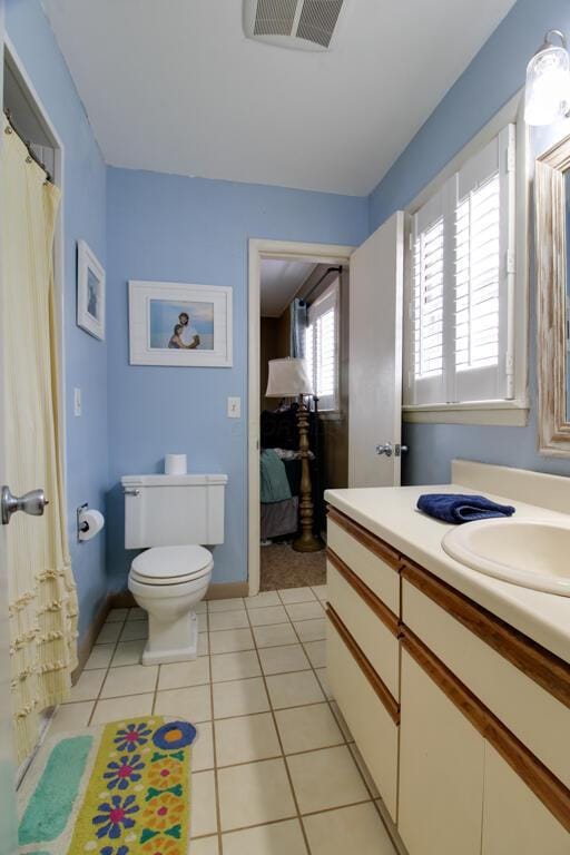 bathroom with tile patterned flooring, vanity, and toilet