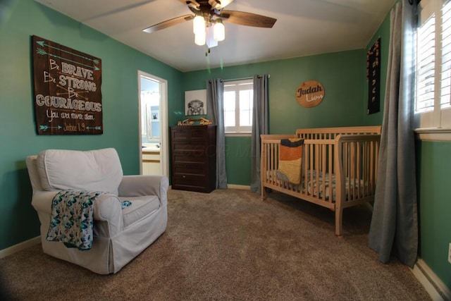 bedroom with carpet, ensuite bathroom, a nursery area, and ceiling fan