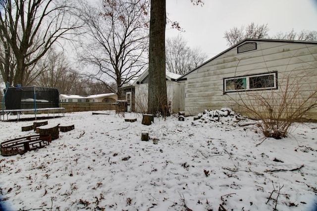 snowy yard with a trampoline