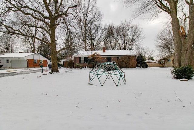 snowy yard with a garage