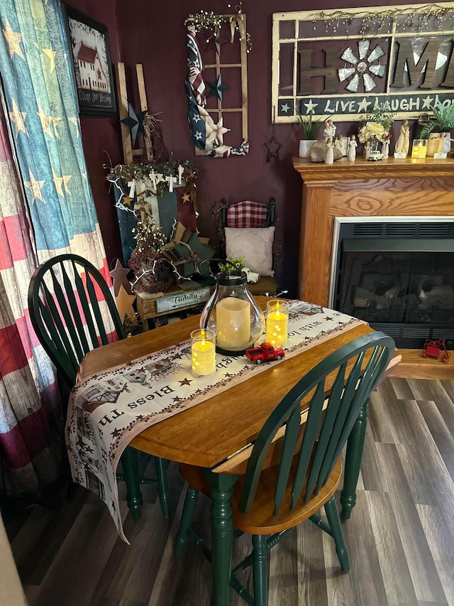 dining room featuring a fireplace and wood finished floors