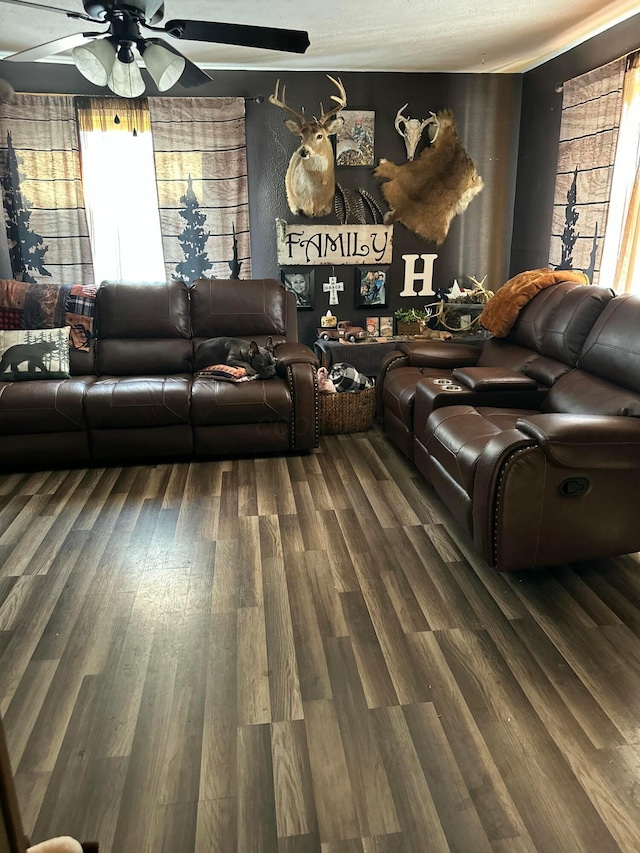 living area with a ceiling fan and wood finished floors