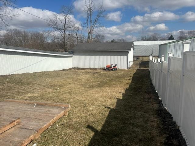 view of yard with an outbuilding and fence