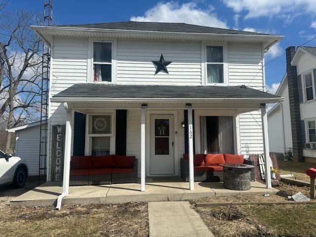 view of front of property featuring outdoor lounge area, roof with shingles, and covered porch