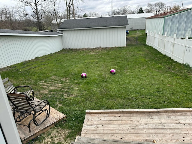 view of yard featuring an outdoor structure, fence, and a deck